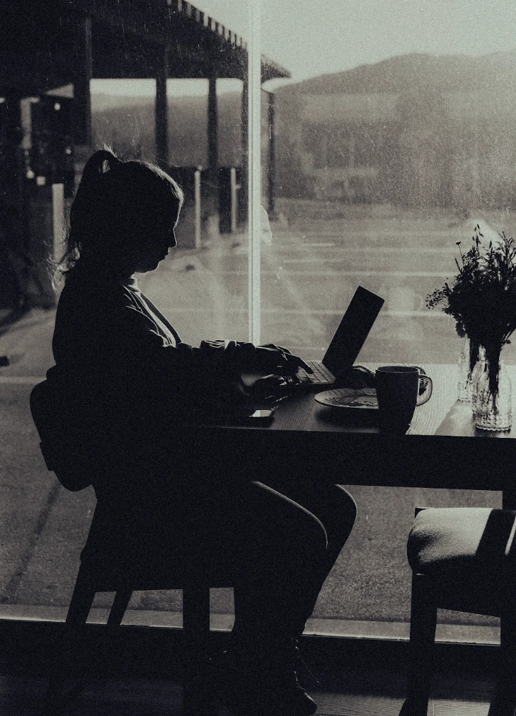Whitesmith team member working on a laptop by a window